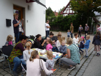 Mitarbeiterinnen schminken Kinder am Feuerwehrhaus. Der Erlös ist für die Patenkinder des Kindergottesdienstteams in Mosambik